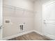 Bright laundry room with wood-look floors, white door and wire rack shelving at 722 English St, Monroe, NC 28110