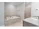 Neutral bathroom featuring soaking tub and tiled walk-in shower at 7358 Bay Cove Ct, Denver, NC 28037