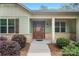 Inviting home entrance with stone accents, a wood door, and well-maintained landscaping at 7358 Bay Cove Ct, Denver, NC 28037