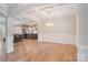 Open-concept living room with hardwood floors, coffered ceilings, and kitchen access at 7358 Bay Cove Ct, Denver, NC 28037
