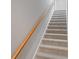 Carpeted staircase featuring a wooden handrail at 7358 Bay Cove Ct, Denver, NC 28037