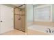 Bathroom featuring a walk-in shower and a separate soaking tub by the window at 7405 Albemarle Dr, Denver, NC 28037
