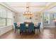 Elegant dining room with modern lighting, hardwood floors, coffered ceilings, and ample natural light at 7405 Albemarle Dr, Denver, NC 28037