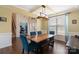Dining area featuring a modern light fixture, beautiful hardwood floors, and view of entryway and staircase at 7405 Albemarle Dr, Denver, NC 28037