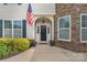 Inviting front entrance with an American flag, beautiful stone accents, and well-maintained landscaping at 7405 Albemarle Dr, Denver, NC 28037
