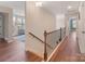Upstairs hallway with hardwood floors and staircase, showcasing the home's architectural details at 7405 Albemarle Dr, Denver, NC 28037