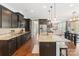 A gorgeous kitchen features dark wood cabinets, granite counters, stainless steel appliances and center island at 7405 Albemarle Dr, Denver, NC 28037