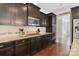 Close up on updated kitchen featuring dark cabinets, granite countertops, stainless steel appliances and modern backsplash at 7405 Albemarle Dr, Denver, NC 28037