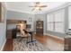 Home office with built-in shelving, desk, ceiling fan, hardwood floors, and a large window at 7405 Albemarle Dr, Denver, NC 28037
