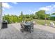 A stone patio in the backyard includes a dining table, furniture, a grill and beautifully maintained landscaping at 7405 Albemarle Dr, Denver, NC 28037