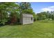 A cute storage shed in the backyard with double doors and metal roof, ideal for organizing outdoor equipment at 7405 Albemarle Dr, Denver, NC 28037