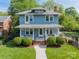 Beautiful two-story home featuring a covered front porch, mature landscaping, and a classic design at 822 W Front St, Statesville, NC 28677