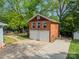 Detached brick garage with two doors and a side entrance, situated in a lush backyard at 822 W Front St, Statesville, NC 28677