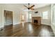 Living room features hardwood flooring, a brick fireplace, and multiple windows for natural light at 822 W Front St, Statesville, NC 28677