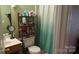 The bathroom features a vanity and shower with green walls and gold accented shower curtain at 8524 Stoneman Pl, Charlotte, NC 28217