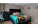Cozy bedroom features a large sunflower themed bedspread and a black headboard at 8524 Stoneman Pl, Charlotte, NC 28217