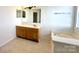 Bathroom featuring a soaking tub, vanity, and neutral tile floors at 8551 Appledale Dr, Charlotte, NC 28262