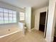 Bright bathroom with a tub, separate shower, and neutral tile flooring at 8551 Appledale Dr, Charlotte, NC 28262