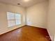 Neutral bedroom featuring a window, closet, and wood-look flooring at 8551 Appledale Dr, Charlotte, NC 28262