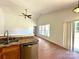 Well-lit kitchen with stainless steel dishwasher, stainless sink, and access to the living room and sliding glass door at 8551 Appledale Dr, Charlotte, NC 28262