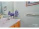 Powder room with wood vanity, sink, and decorative hand towel and floral arrangement at 940 Hatchett Rd, Lincolnton, NC 28092