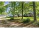 View of the house from a tree-lined drive way; includes a detached shed and space for a RV at 940 Hatchett Rd, Lincolnton, NC 28092