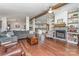Open living room featuring hardwood floors, stone fireplace, wood beams, and a view to the kitchen at 940 Hatchett Rd, Lincolnton, NC 28092