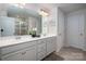 A well-lit bathroom features a double sink vanity with neutral walls, and a glass enclosed shower at 9613 Fire Bellied Ct, Lancaster, SC 29720