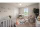 A well-lit Bedroom, featuring a crib, changing table, and a cozy rocking chair at 9613 Fire Bellied Ct, Lancaster, SC 29720