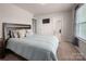 Bedroom with an open door to a connecting room, featuring a large window and plush bedding at 9613 Fire Bellied Ct, Lancaster, SC 29720