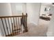 Hallway with beautiful wooden railings leading to a bright, carpeted staircase and a view into a living room at 9613 Fire Bellied Ct, Lancaster, SC 29720