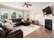 Comfortable living room features a cozy fireplace, large windows, hardwood floors, and a plush leather couch at 9613 Fire Bellied Ct, Lancaster, SC 29720