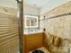 Tiled bathroom featuring a shower with glass door, double sink vanity, and illuminated mirror at 970 Mt Moriah Church Rd, China Grove, NC 28023