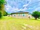 Back view of brick house with a well-kept lawn and partial view of a second building on property at 970 Mt Moriah Church Rd, China Grove, NC 28023