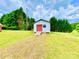 A practical outbuilding with a red door and ramp, set in a spacious green yard at 970 Mt Moriah Church Rd, China Grove, NC 28023