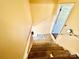 Unfinished stairway with yellow walls leads to a bright, white door, showing renovation potential at 970 Mt Moriah Church Rd, China Grove, NC 28023