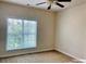 Cozy bedroom featuring a ceiling fan and one large window at 9832 Longstone Ln, Charlotte, NC 28277