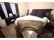 This cozy bedroom includes a comfortable bed with a plush blanket and dark curtains at 9832 Longstone Ln, Charlotte, NC 28277