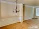 Dining area with elegant wainscoting and a stylish chandelier at 9832 Longstone Ln, Charlotte, NC 28277