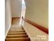 Carpeted staircase with wooden railing at 9832 Longstone Ln, Charlotte, NC 28277