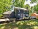 The backyard is landscaped with a concrete patio, wooden deck, and lush greenery at 10024 Whitethorn Dr, Charlotte, NC 28277