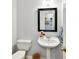 Half bathroom featuring pedestal sink, toilet, and decorative mirror at 10024 Whitethorn Dr, Charlotte, NC 28277