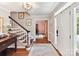 Welcoming foyer featuring wood floors, a staircase with a white railing, and elegant lighting at 10024 Whitethorn Dr, Charlotte, NC 28277