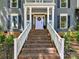 Welcoming front porch with brick steps and a white railing leading to a charming light purple front door at 10024 Whitethorn Dr, Charlotte, NC 28277