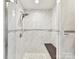 Modern shower with marble tile, a built-in bench, and a sleek shower head at 10024 Whitethorn Dr, Charlotte, NC 28277