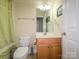 Cozy bathroom with a toilet, shower with curtain, vanity with sink, and a mirror at 10944 Persimmon Creek Dr, Mint Hill, NC 28227