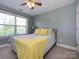 Bright bedroom featuring large windows, a ceiling fan, and cozy furnishings, creating a comfortable and inviting space at 10944 Persimmon Creek Dr, Mint Hill, NC 28227
