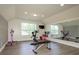 Bright exercise room with hardwood flooring, mirrored wall, and exercise equipment at 10944 Persimmon Creek Dr, Mint Hill, NC 28227