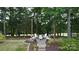 Charming backyard firepit area with stone pavers, Adirondack chairs and lush greenery, perfect for outdoor gatherings at 10944 Persimmon Creek Dr, Mint Hill, NC 28227