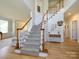 Bright foyer with hardwood floors, staircase with white railing, and decoratively appointed console table at 10944 Persimmon Creek Dr, Mint Hill, NC 28227